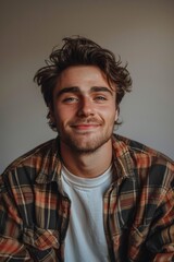 Obraz premium Handsome smiling, happy and pleased stoic man with positive vibes. Portrait of a joyful young man with beautiful hair and fashionable clothes.