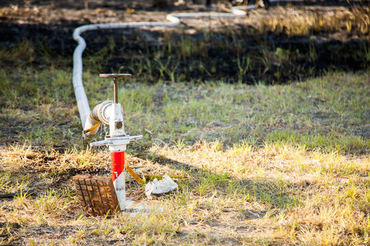 Fire hydrant beside burnt property with fire hose attached