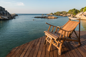 Wood armchair by sea with stone arch, Ko Man Klang, Rayong