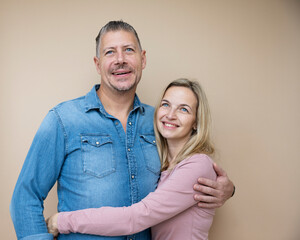 couple in love posing in front of brown background, middle age