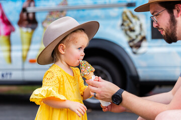 Young Aussie girl at local event eating ice-cream with sprinkles on Australia Day