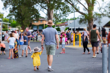 Dad walking through crowds at event with toddler