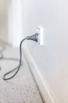 Vacuum cleaner plugged into a power point with child cover over the second one