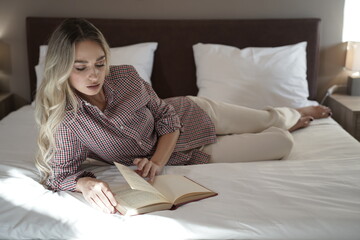 Woman with blond hair and beautiful face reading a book