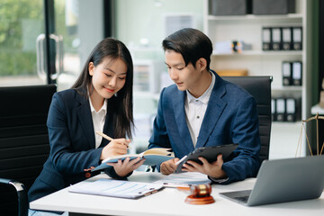 Asian business team and lawyers discussing contract papers sitting at the table. Concepts of law, advice, legal services.