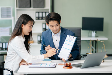 Judge gavel with scales of justice, Business and lawyer or counselor consulting and discussing contract papers with laptop and tablet at law firm