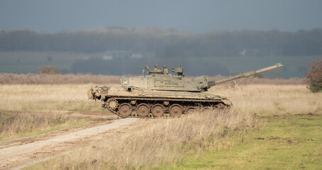 Fototapeta premium Commander and gunner directing a British army Challenger 2 II FV4034 main battle tank in action on a military exercise