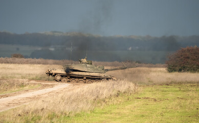 Fototapeta premium Commander and gunner directing a British army Challenger 2 II FV4034 main battle tank in action on a military exercise