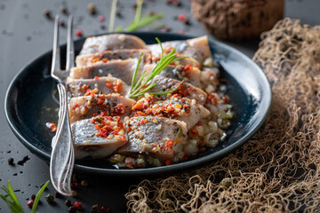 Spicy and sour marinated herring on old fishing net. - 759637601