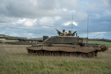 Commander and gunner directing a British army Challenger 2 II FV4034 main battle tank in action on a military exercise, taking aim