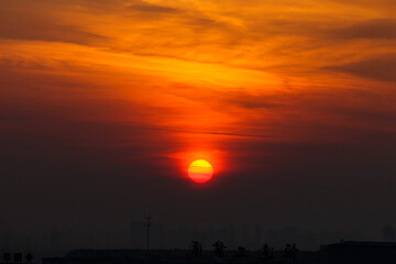 the sun rising through the clouds