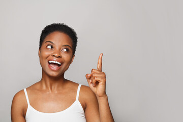 Attractive happy woman pointing up on white background