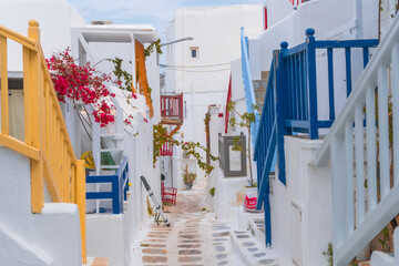 narrow side street with traditional whitewashed walls and blue accents in Mykanos Greece....