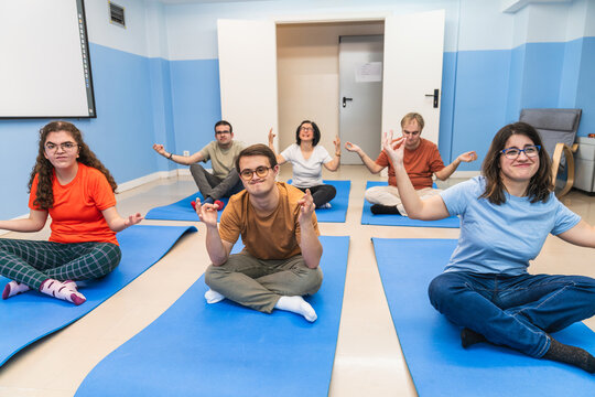 Joyful yoga participants with mental disabilities, including with Down syndrome.