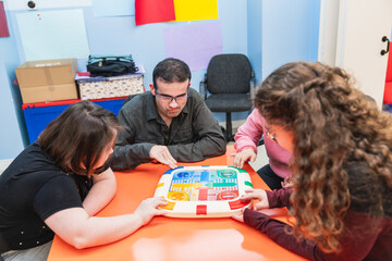 Individuals with a person with Down syndrome engaged in a learning game.