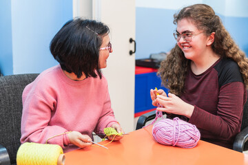 Two mentally disabled students share a joyful moment in sewing class.