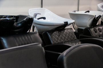 Hair washing sinks and beauty salon chair. One is a black and white sink and the other is a black and white bowl. This is a professional and functional space for providing hair care services.