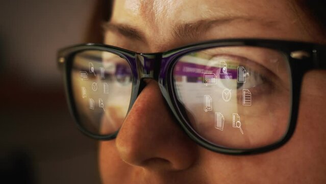 Cg footage with reflection in glasses on a female face searching for information on the Internet and rotating symbols of business documentation