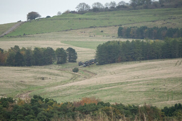 convoy of army trucks moving in the countryside