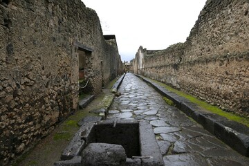 Cobbled streets of the city of Pompeii. Wet streets and cloudy skies. Ancient Roman city buried after the eruption of the Vesuvius volcano in 79AD