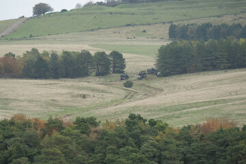 convoy of army trucks moving in the countryside