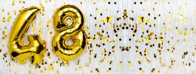 Golden foil balloon number, figure forty-eight on white with confetti background. 48th birthday card. Anniversary concept. birthday, new year celebration. banner