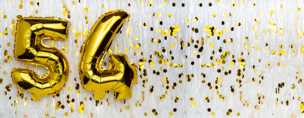 Golden foil balloon number, figure fifty-four on white with confetti background. 54th birthday...