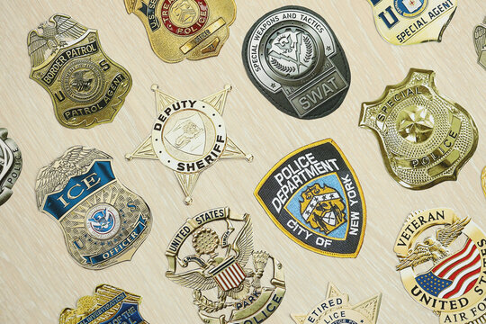 KYIV, UKRAINE - MARCH 9, 2024 Badges of different United States police departments printed on paper close up