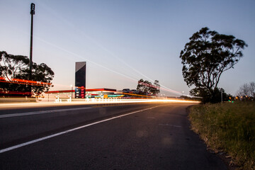Light trail going past petrol station on country highway