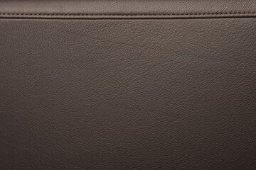 Texture of full grain brown leather with stitching on top