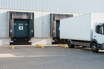 white truck at loading ramps of a warehouse