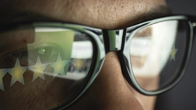 Cg footage with a reflection in glasses on a male face searching for information on the Internet and five stars as a symbol of evaluation