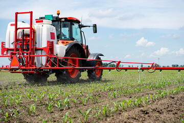 Tractor spraying pesticides at corn fields