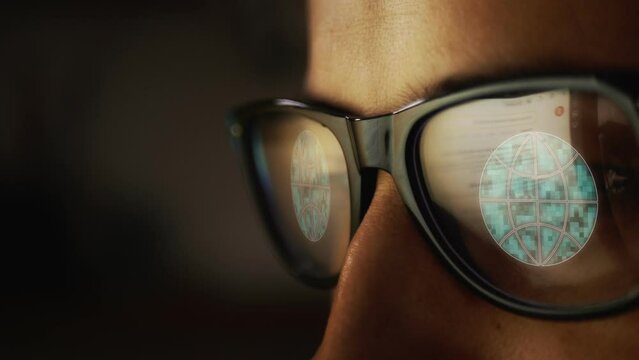 Cg footage with a reflection in glasses on a male face searching for information on the Internet and a symbol of planet Earth with parallels and meridians