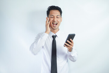 Adult Asian man showing surprised face expression when holding mobile phone
