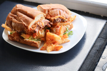 Masala steak Gatsby. South African fast food roll filled with chips, steak, braised onions and sauce. 