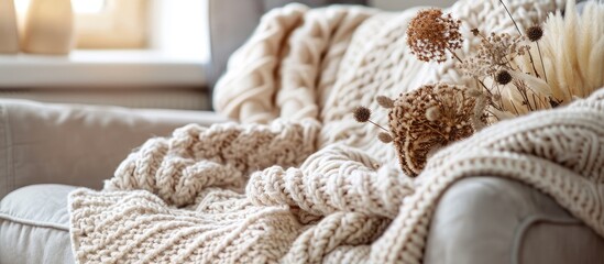 Fototapeta na wymiar Knitted sweater on armchair in warm and cozy living room, top view