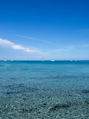 Villasimus, Sardegna. The wonderful bay of Porto Giunco. Sea in shades of turquoise blue. Tourist destination. Sea of Sardinia one of the most beautiful in Italy. Boats off the coast