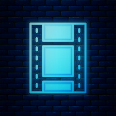 Glowing neon Play Video icon isolated on brick wall background. Film strip sign. Vector