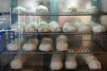 Shop's steamed buns In the glass food warming cabinet, there are water droplets and hot steam inside.