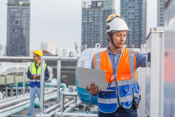 Man engineer holding laptop working at rooftop building construction. Male technician worker...
