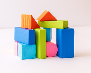 colorful wooden blocks arranged in the shape of a building  on white background