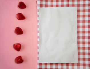 dried fruits on a pink background and an empty package on a picnic blanket. mokup work concept shot