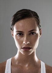 Woman, serious face and confident for fitness, strong and determined with sweat from workout on grey background. Headshot, portrait and athlete for sports, exercise with pride and power in studio