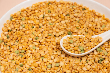 Pea yellow groats grains cereal in spoon close-up macro.