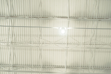 Spot light hanging at modern suspended ceiling metal roof structure, warehouse industry factory building lighting solution, stretch ceiling perimeter track and membrane clicks into, Frisco, TX - obrazy, fototapety, plakaty