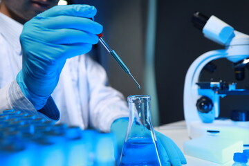 A chemist is testing a newly discovered chemical using a variety of scientific equipment in his lab, The working atmosphere in the laboratory while scientists are doing research.