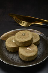 mini bake luxury tart in Japanese hojicha crisp with cranberry pineapple jam paste inside with clove stick and black plate gold fork knife on dark background pastry dessert halal party food menu