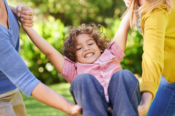 Kid, women or swing to play as family, lgbt or lesbian parents as diverse, inclusive or adoption. Couple, boy or holding hands to support, trust or care as bonding together in park on spring morning