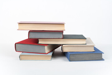 Book stack, hardback colorful books on wooden table, white background. Back to school. Copy space for text. Education business concept.